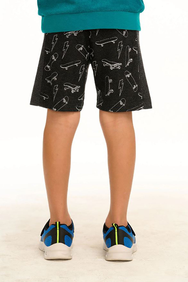 Skateboard and lightning bolt shorts in black back view