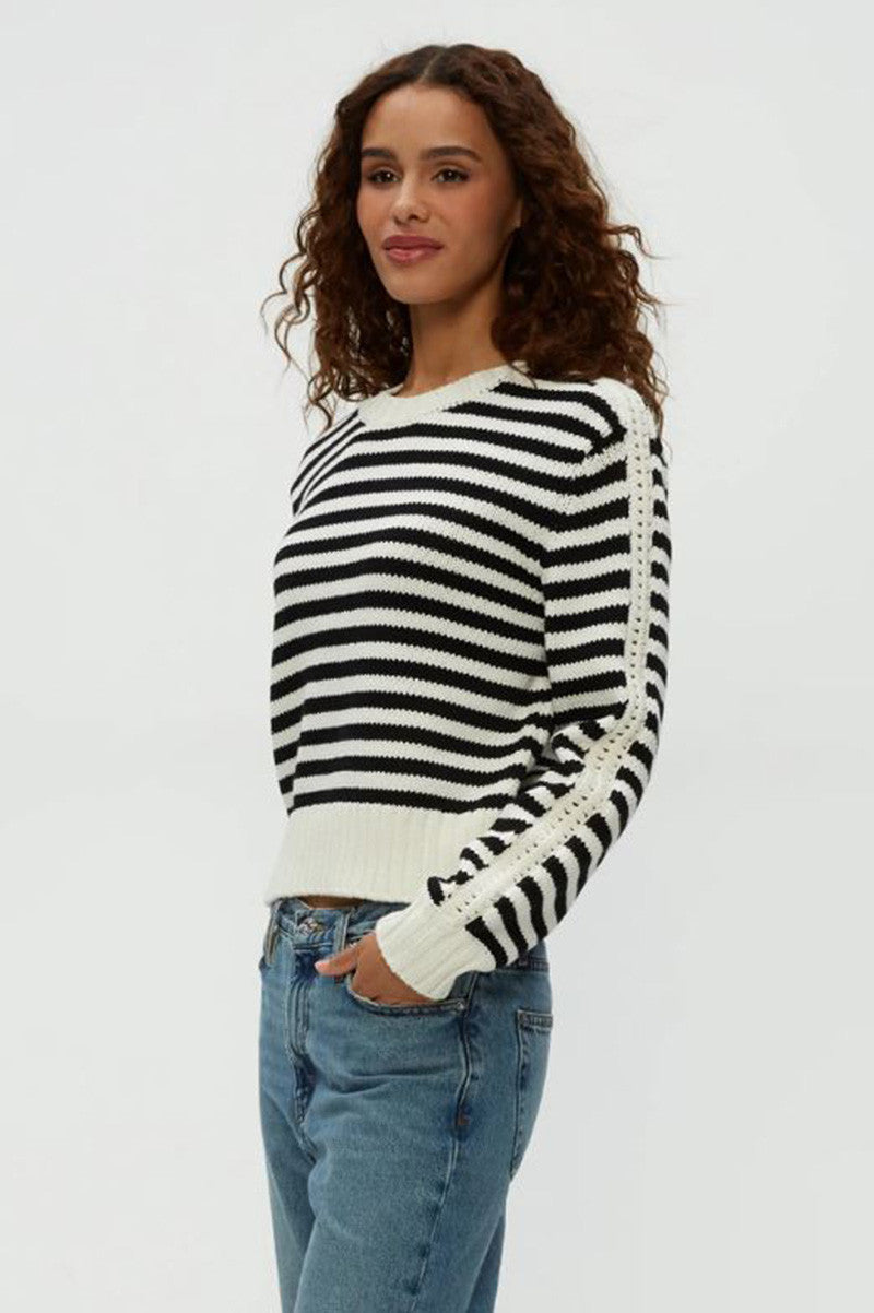 Black-and-white striped crewneck sweater, side view, ribbed cuffs and hem