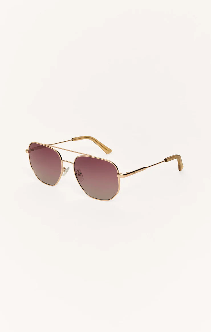 Aviator sunglasses, dark berry gradient lenses with gold frame, angled view
