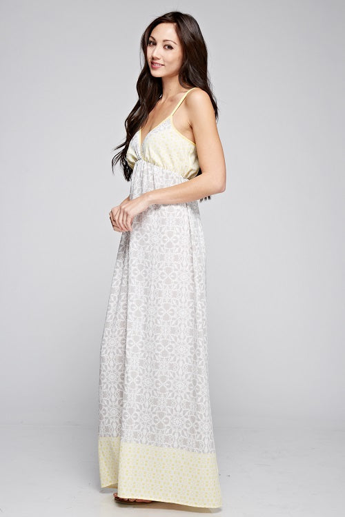 Floral sleeveless maxi dress with light gray pattern and yellow accent hem