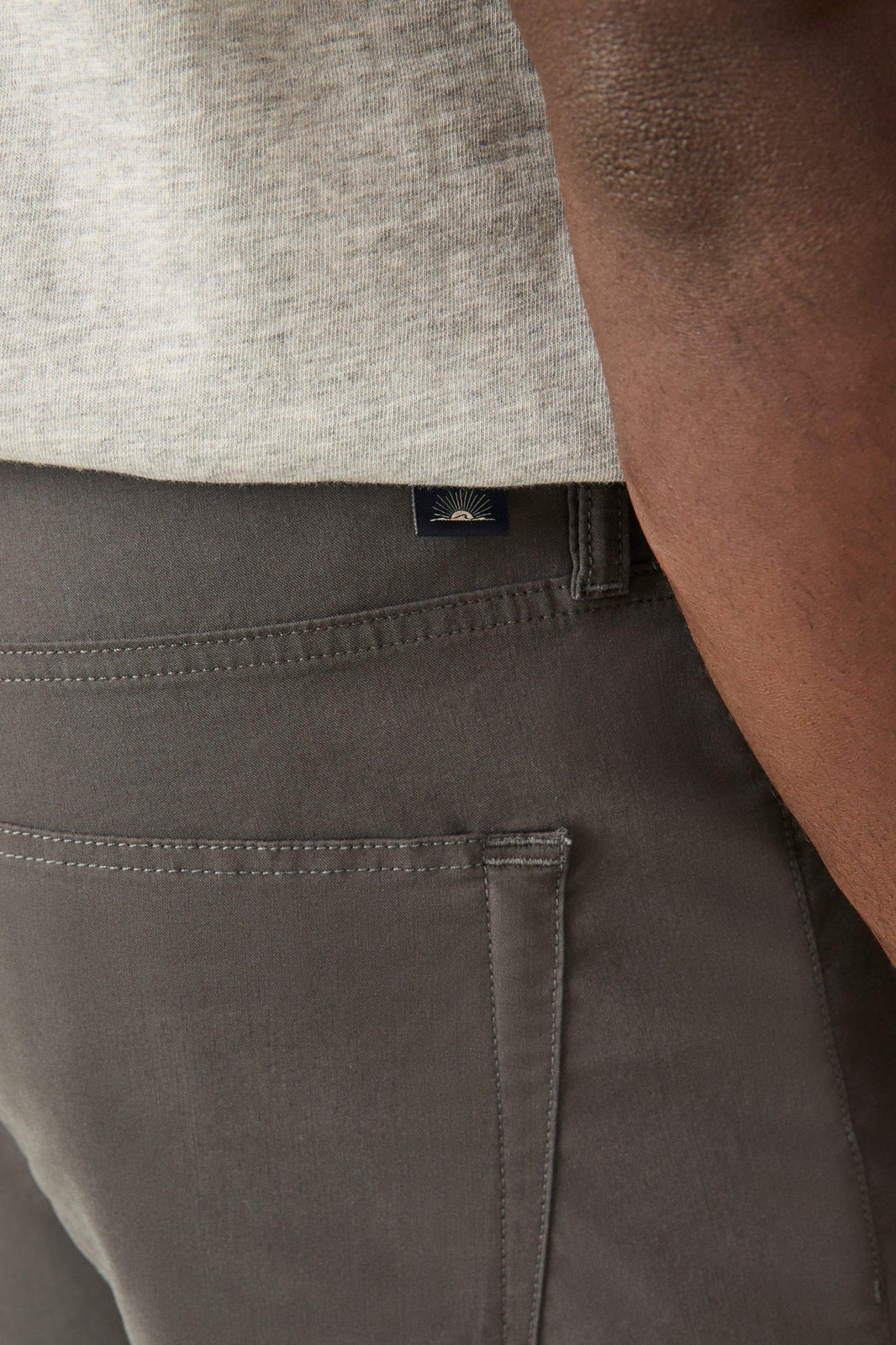 Graphite pocket pant close-up: front seam, side pocket, woven logo patch