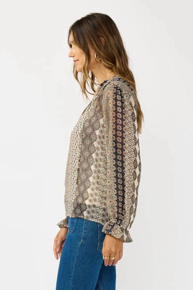 Long-sleeve blouse in beige and navy tile pattern with gathered ruffle cuffs