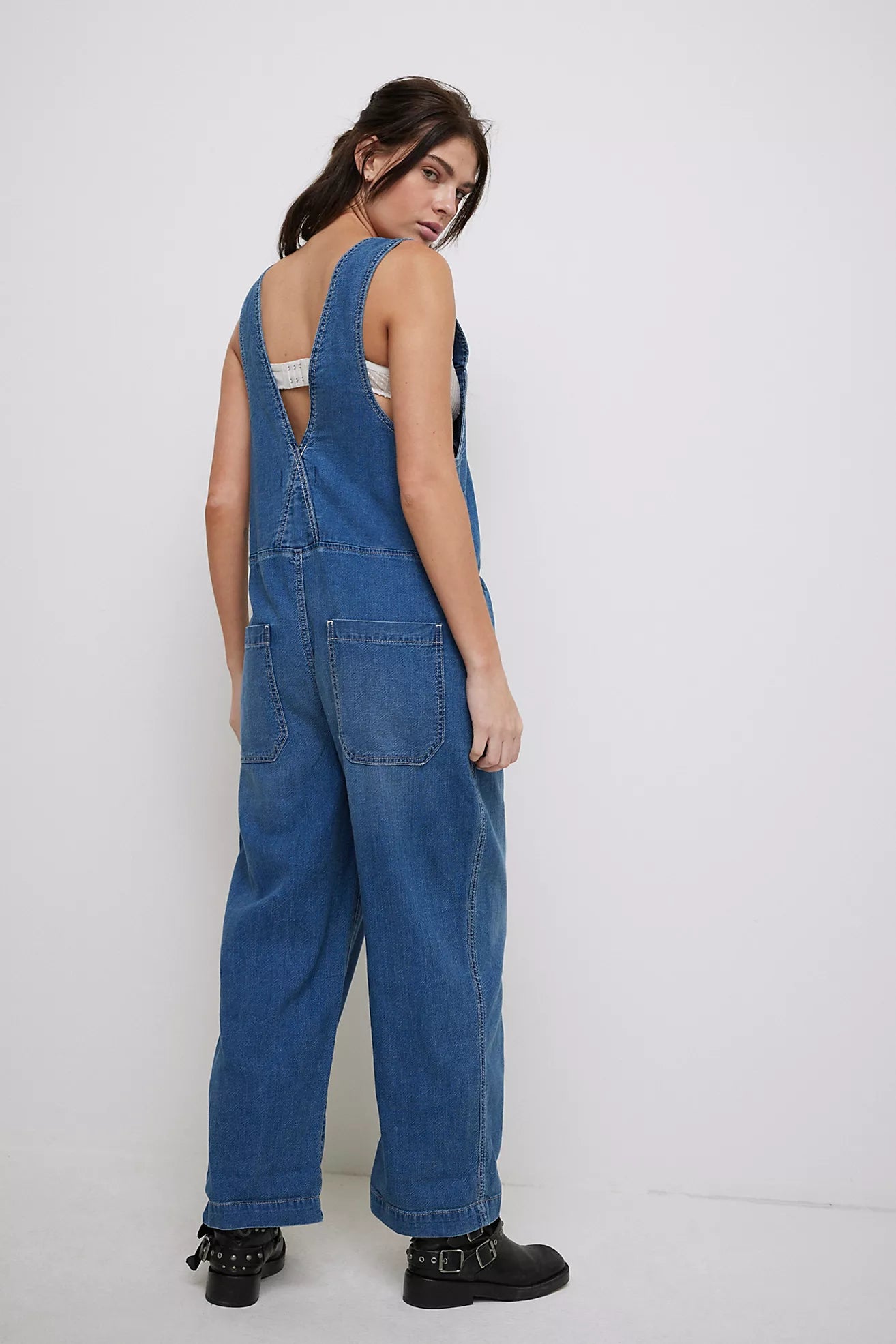 Mid indigo denim backless jumpsuit with square neckline, wide legs and back pockets