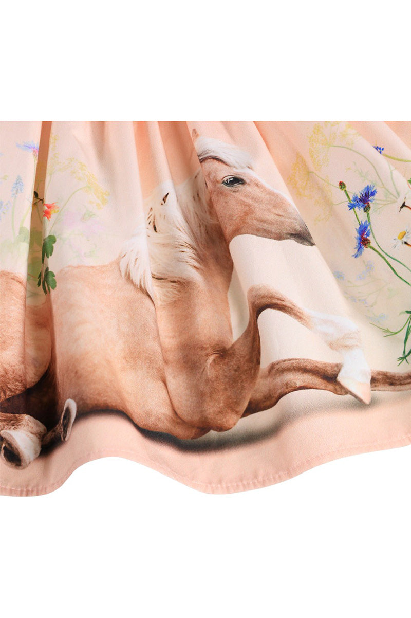 Girls' skirt fabric close-up with tan dog face and wildflower animal print detail