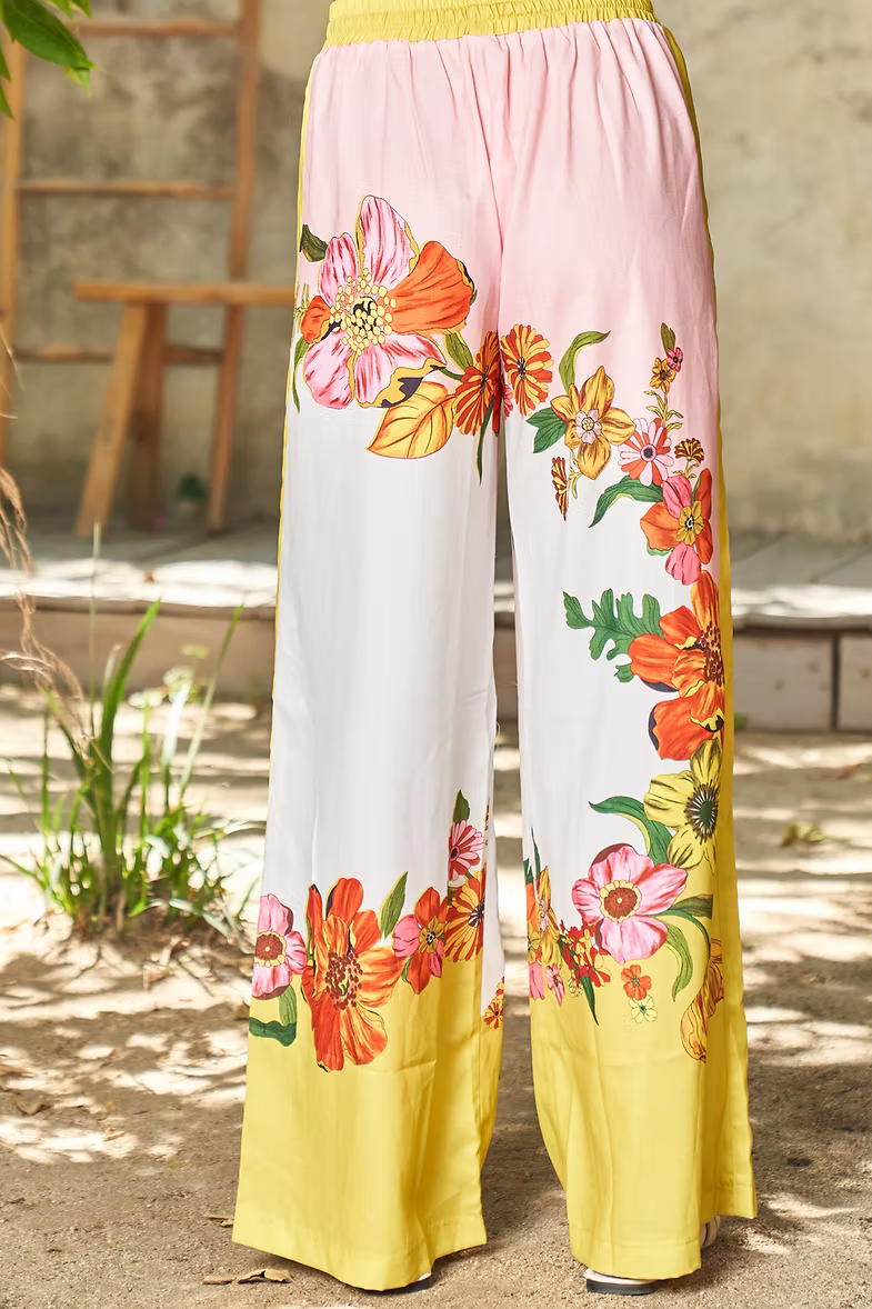Wide-leg pull-on pants with floral print, pink and yellow color blocks, elastic waist.