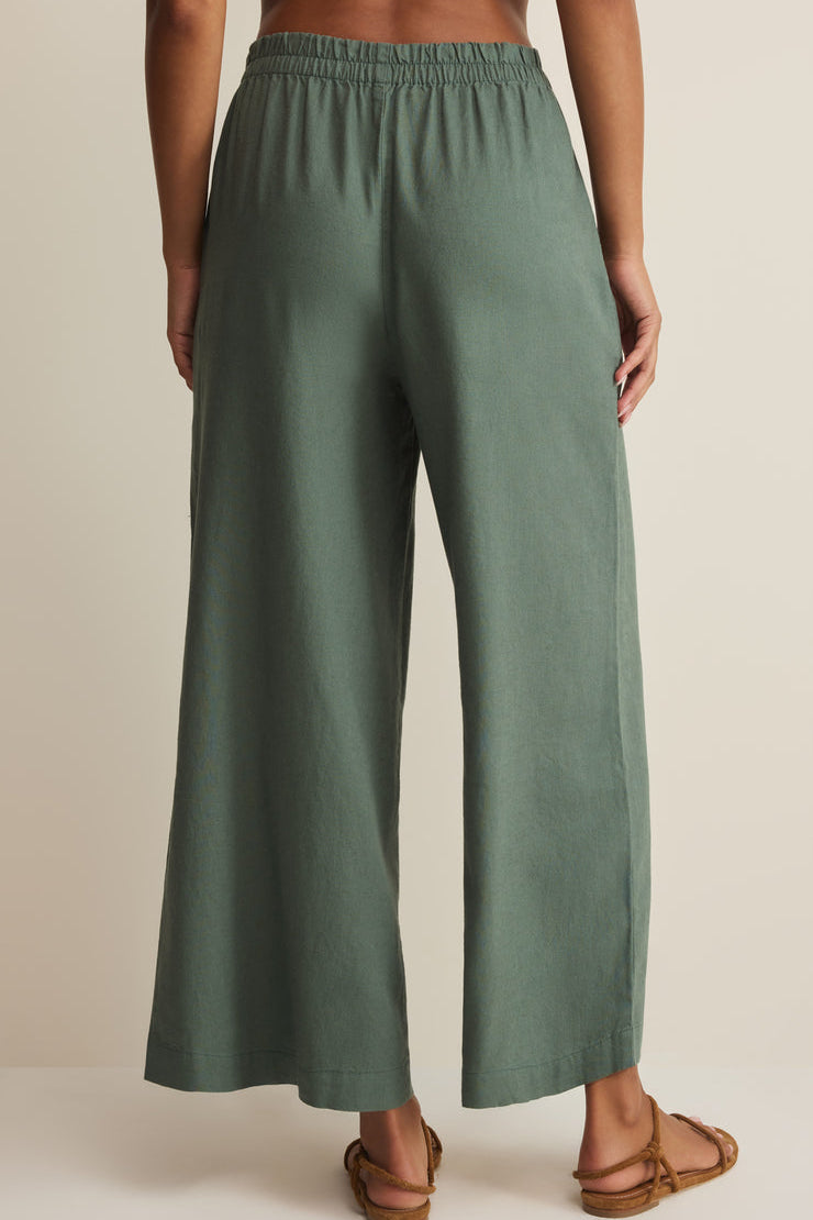 Green wide-leg linen pants with gathered elastic waistband, full length.