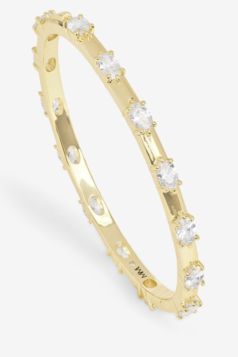 Gold tone cuff bracelet with round clear stones along top and sides