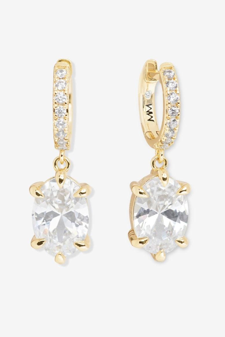 Gold earrings with clear gemstones on a white background