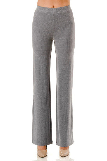 A pair of gray ribbed knit wide-leg pants shown on a model from the waist down, paired with beige heels against a plain white background.