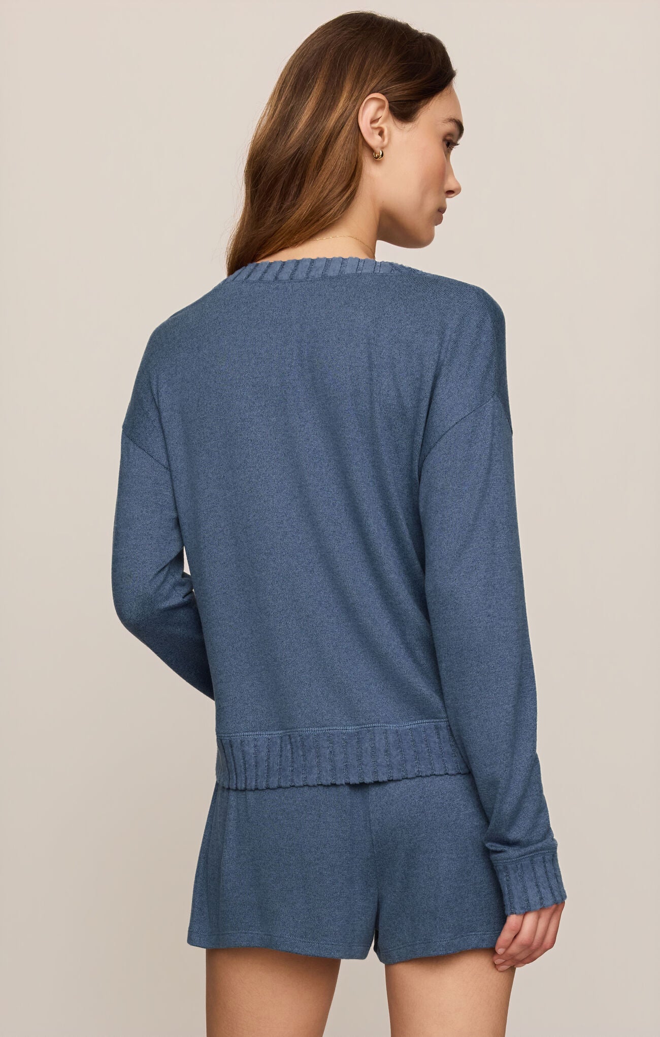 Back view of woman wearing a Courtney Long Sleeve top in True Navy and matching shorts on a beige background