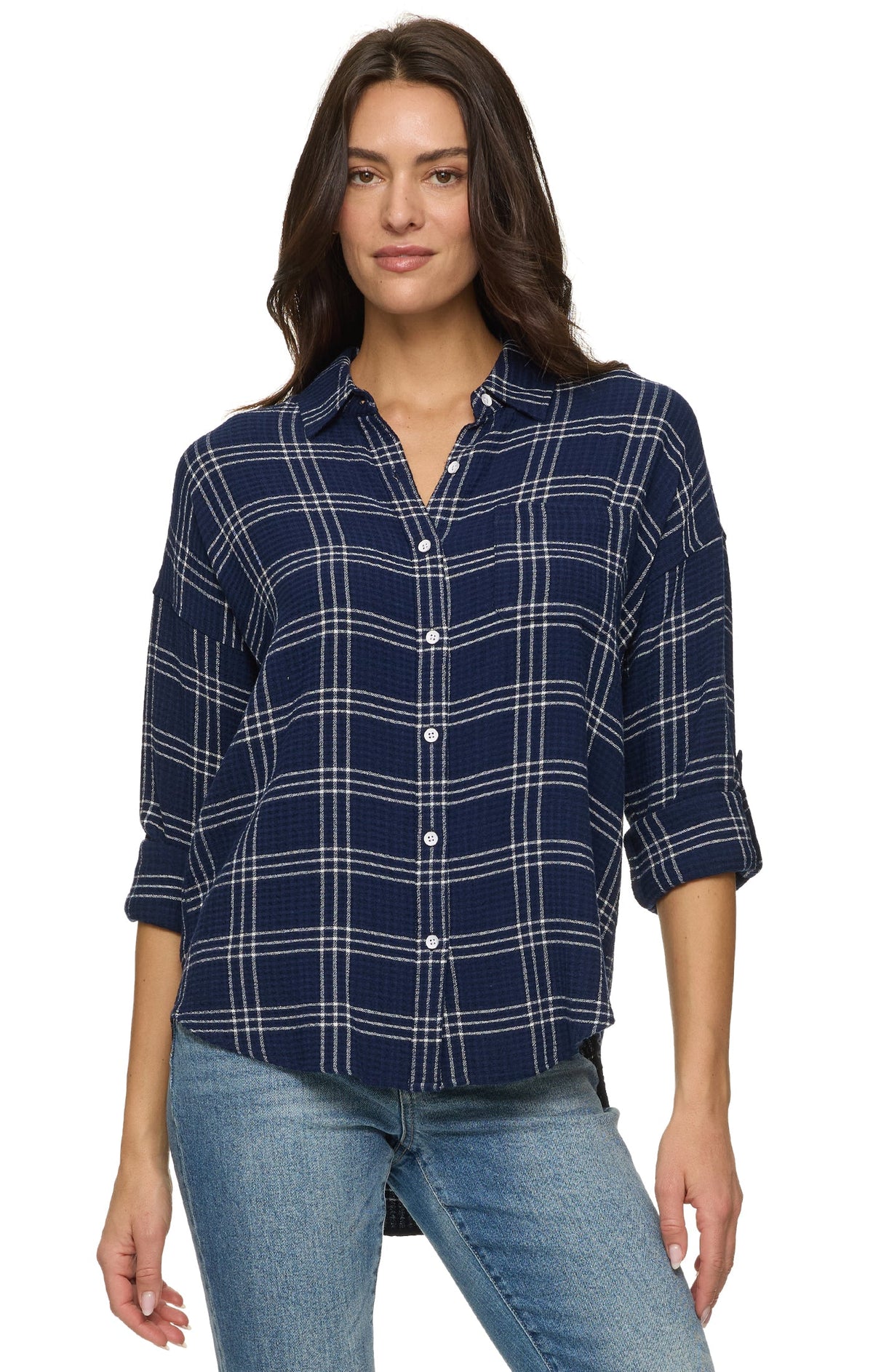 A woman wearing a navy blue plaid button-up shirt with white stripes and light blue jeans, photographed against a plain white background.