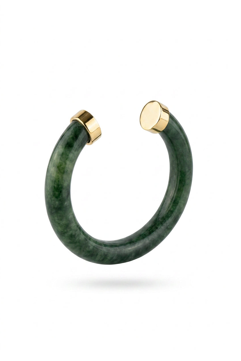 A green jadeite huggie cuff bracelet with polished gold-toned metal end caps, shown on a clean white background.
