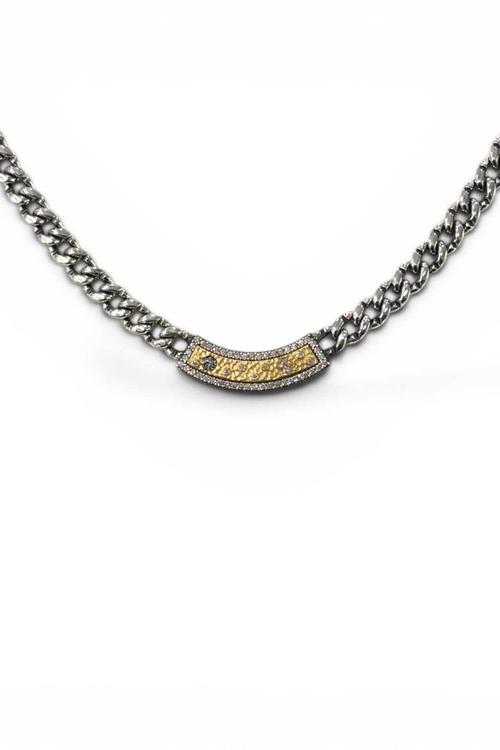 A silver-toned Soleil ID Cuban link chain necklace with a central curved bar set with small clear stones and a textured gold center, shown on a plain white background.