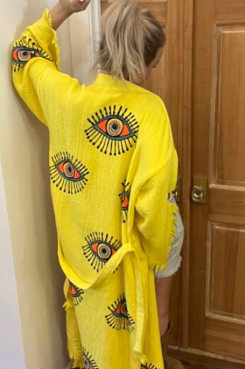 Women’s bright yellow kaftan with multicolor eye motifs and tassel fringe hem
