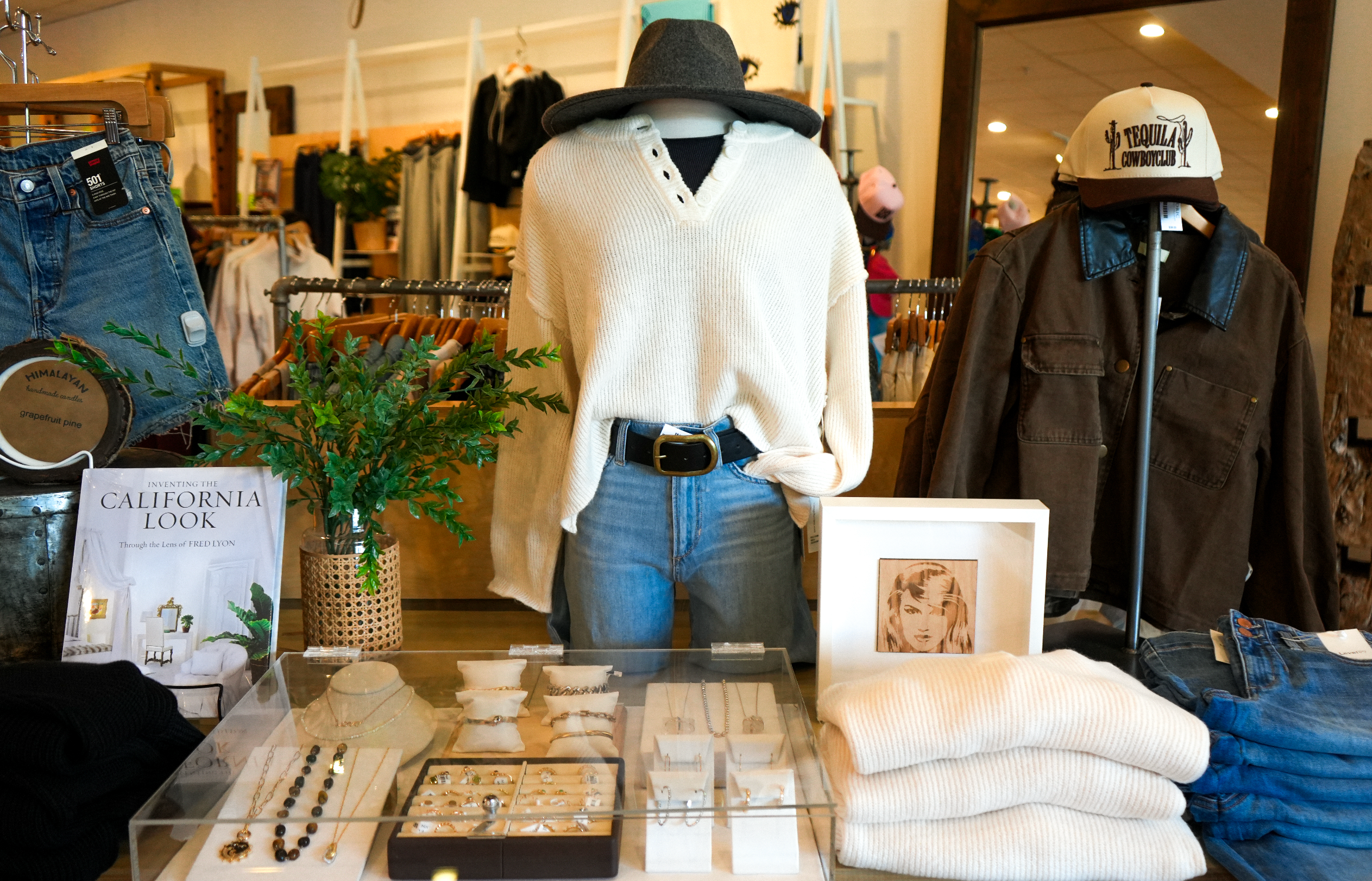 Boutique merch table with sweaters, denim and jewelry