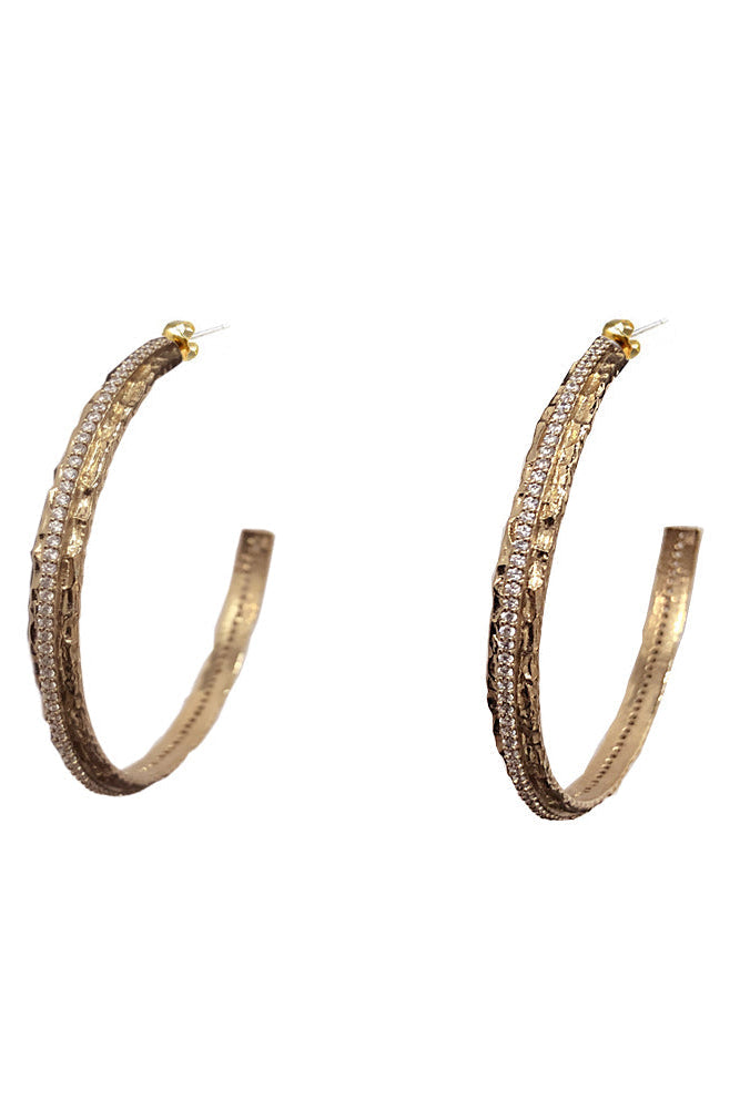 A pair of egyptian gold hoop earrings embellished with rows of small clear pavé stones, shown against a plain white background.