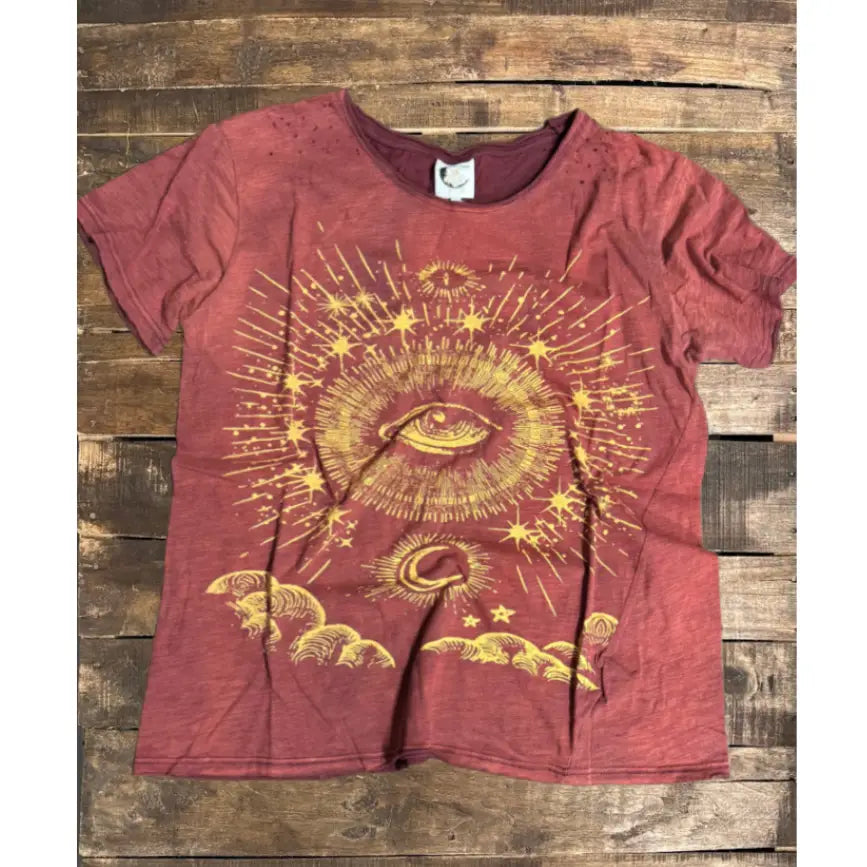Burgundy graphic T-shirt with glowing sunburst, eyes, and small celestial stars