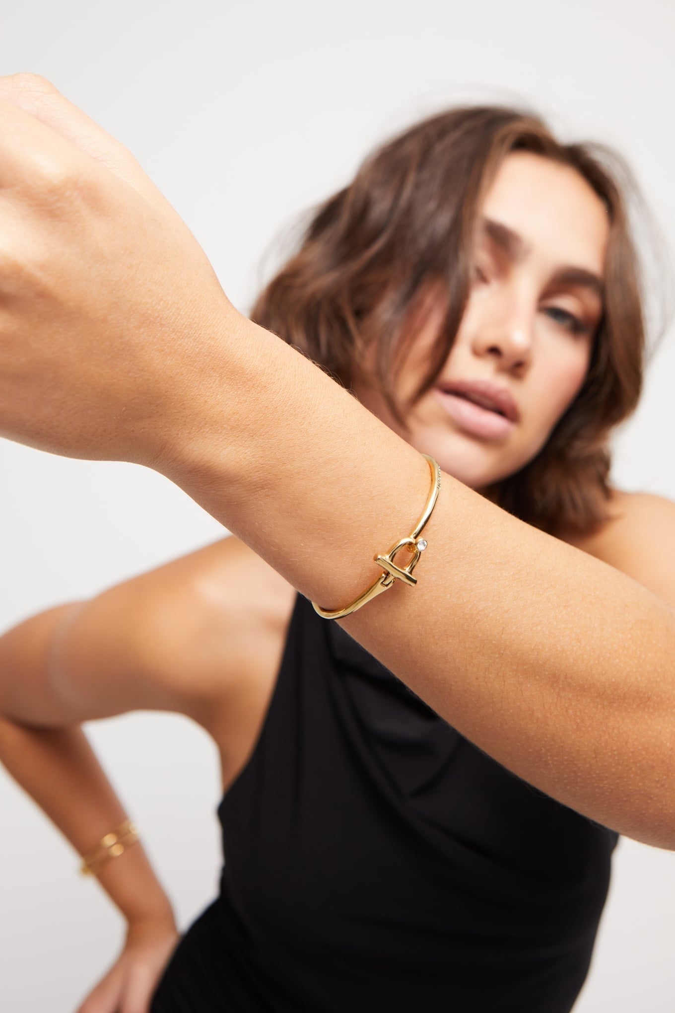 Indomable bracelet in gold tone with knot charm and small clear stone on wrist