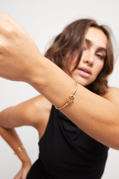 Indomable bracelet in gold tone with knot charm and small clear stone on wrist