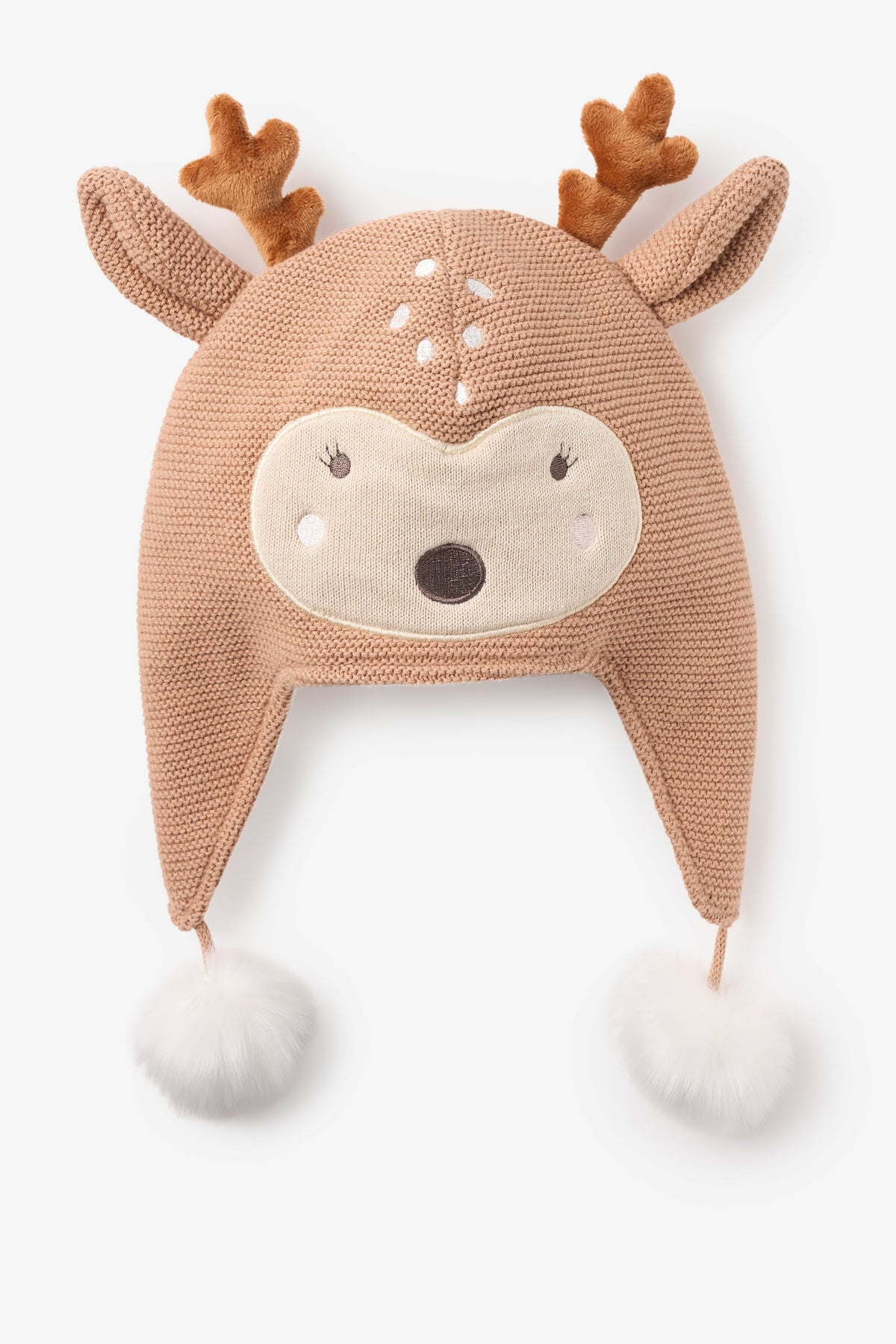 A knit baby hat shaped like a fawn face, in a warm tan color with brown antlers, a cream embroidered face, and white pom-poms at the ear flaps, shown on a light gray background.