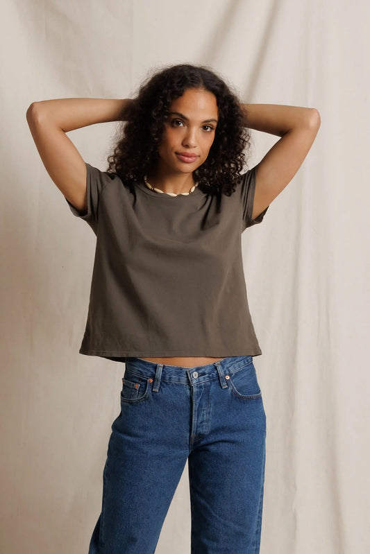 Woman wearing the Harley Boxy Crew Tee in Dark Olive with medium wash blue jeans 