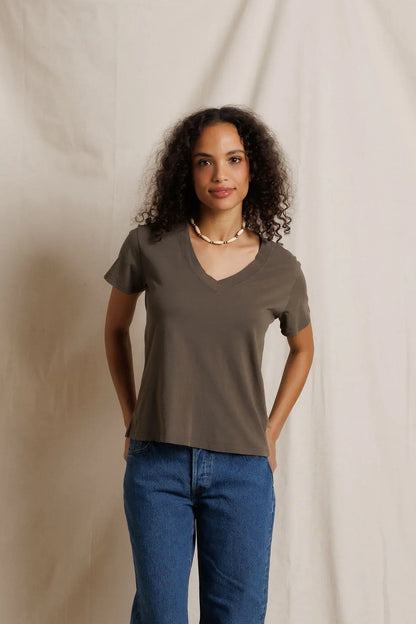 Woman wearing the Hendrix Vneck tee in Dark Olive with blue jeans 