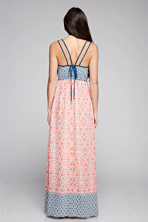 Back view maxi dress with coral floral print, blue waistband trim, crossed spaghetti straps