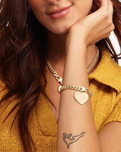 Gold heart charm bracelet on wrist, Cuban links and box clasp