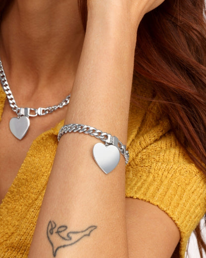 Silver heart charm bracelet on wrist, Cuban links and box clasp