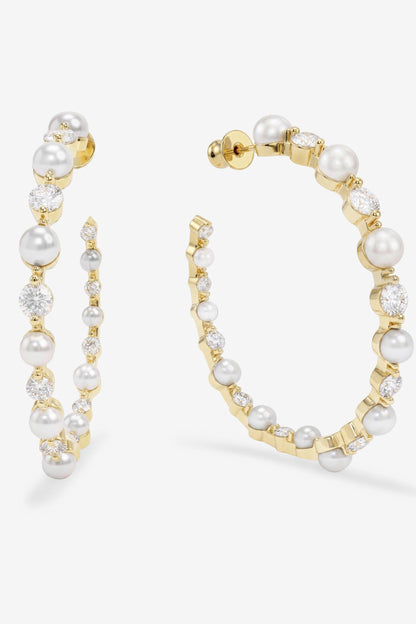 Gold hoop earrings with pearls on a white background