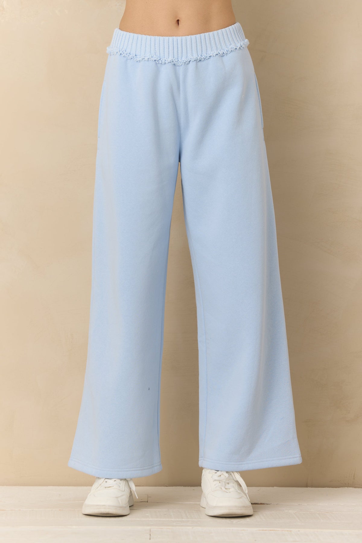 Lake blue fleece rib pants worn by a person on a beige background
