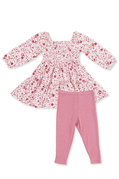 A toddler girl's two-piece outfit set featuring a long-sleeve smocked dress with a red and pink serene floral print on a white background, paired with solid dusty pink leggings, laid flat on a white background.