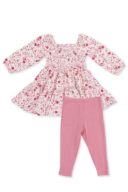A toddler girl's two-piece outfit set featuring a long-sleeve smocked dress with a red and pink serene floral print on a white background, paired with solid dusty pink leggings, laid flat on a white background.