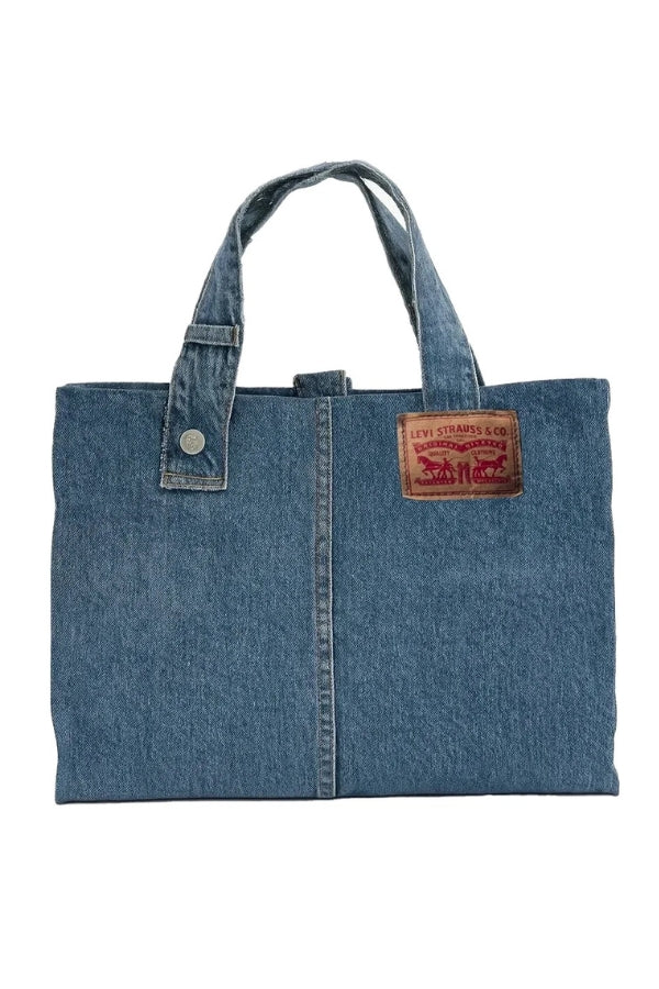 Blue denim tote bag with a brand label on a white background