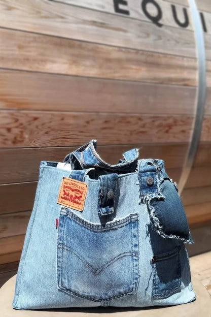 Denim handbag with a visible brand label against a wooden background