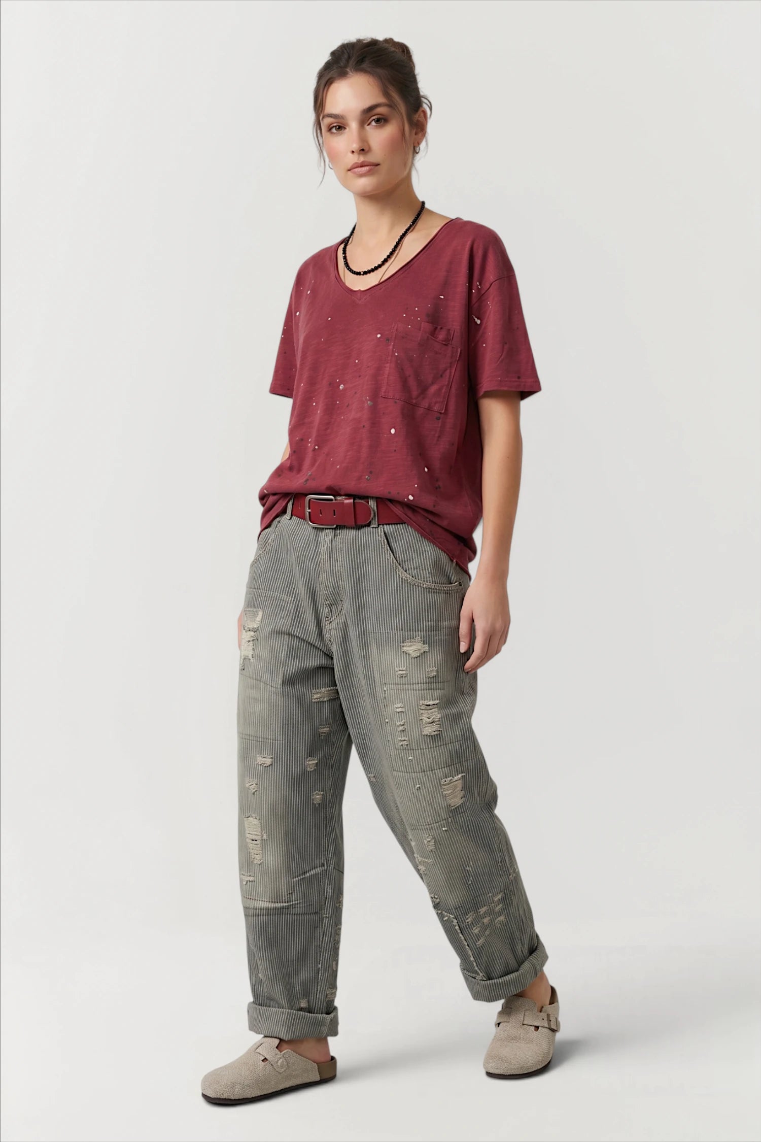 Front view of woman wearing a red shirt and peace & love jeans in midnight railroad 