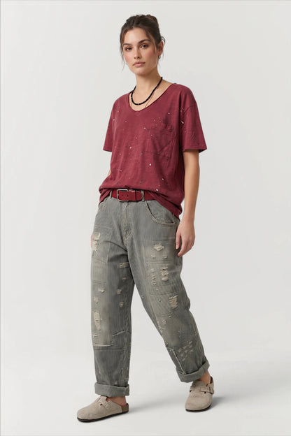 Front view of woman wearing a red shirt and peace & love jeans in midnight railroad 