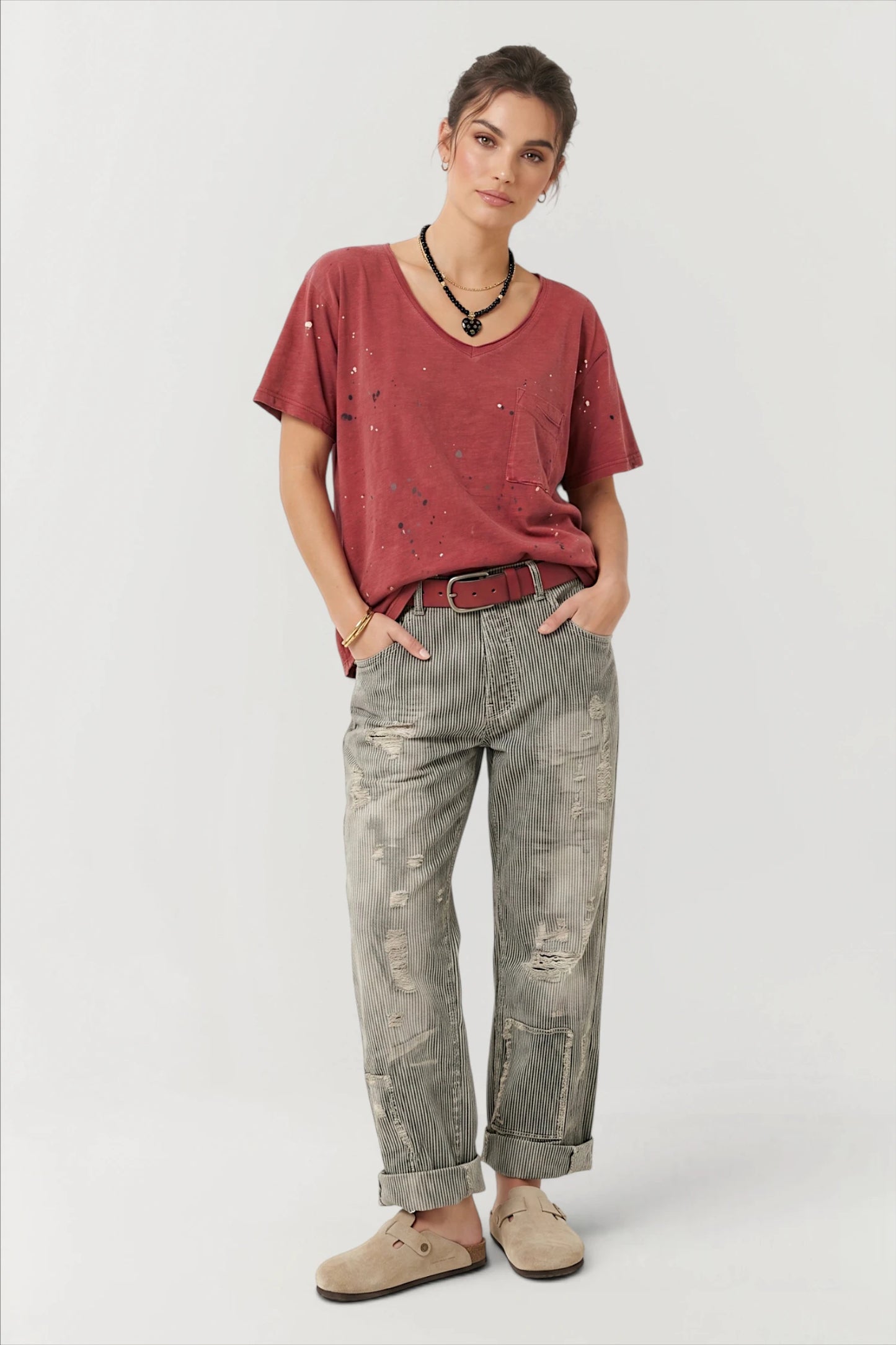 Woman wearing a red shirt and peace & love jeans in midnight railroad 