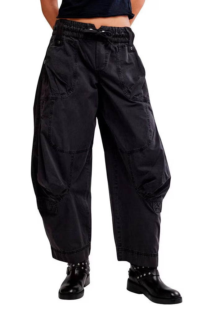 Black Sand colored wide-leg cargo pants with an elastic waistband, modeled on a person wearing black studded boots against a plain white background.