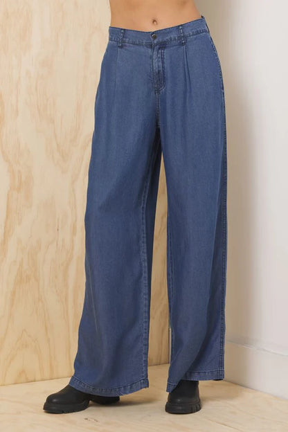 Dark blue wide-leg denim trousers, front button closure, back darts and patch pockets