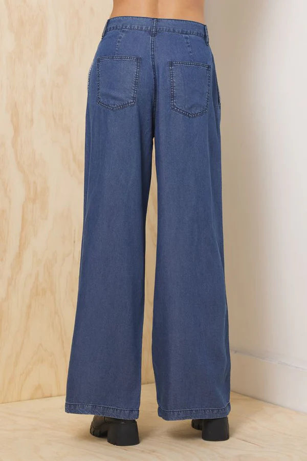 Dark blue wide-leg denim trousers with back yoke and patch pockets, relaxed fit