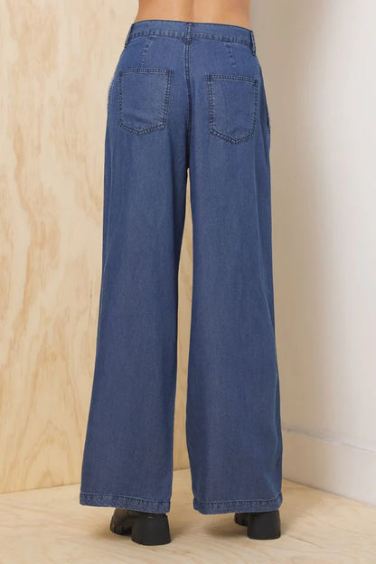 Dark blue wide-leg denim trousers with back yoke and patch pockets, relaxed fit