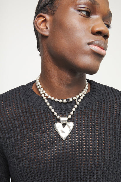 Silver-tone long heart pendant necklace with ball chain, close-up