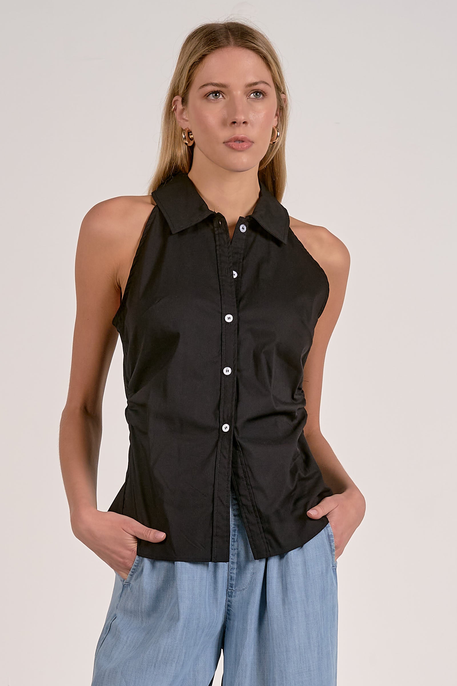 Black sleeveless button-up top with pointed collar and front placket
