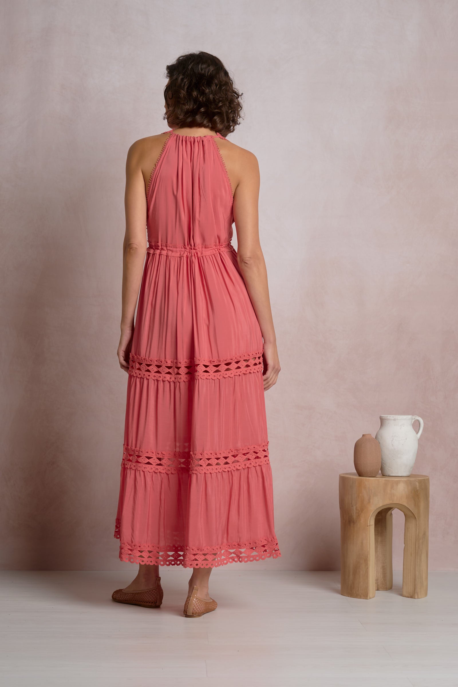 Maxi halter dress in bright pink, back view with tiered ruffles and lace trim