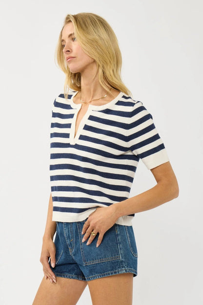 Cream and navy striped polo top with short sleeves and V-neck collar