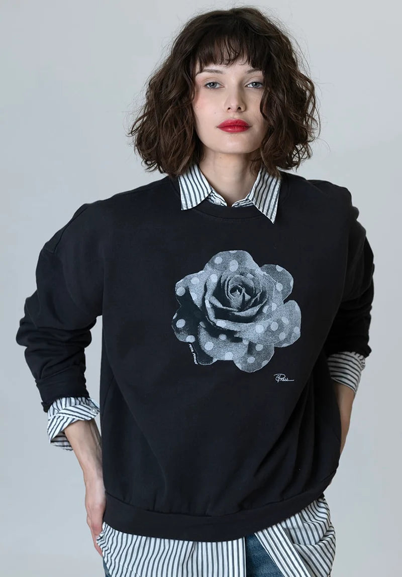 Cozy sweatshirt in dark worn black with crew neck, long sleeves, and light rose graphic.
