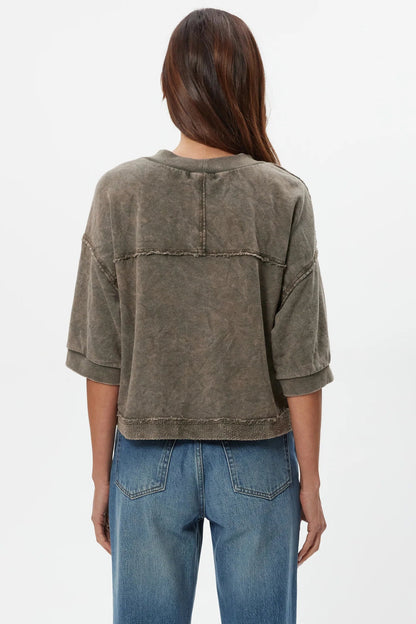 Back view of dark caper wide-sleeve cardigan with yoke seam and stitched hem