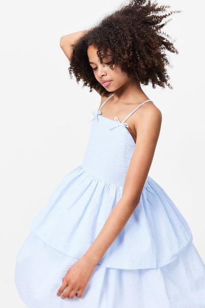 Chelsea dress in light blue seersucker with spaghetti straps and bow-tied neckline