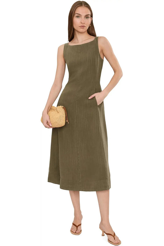 Woman wearing a green dress holding a small bag on a white background